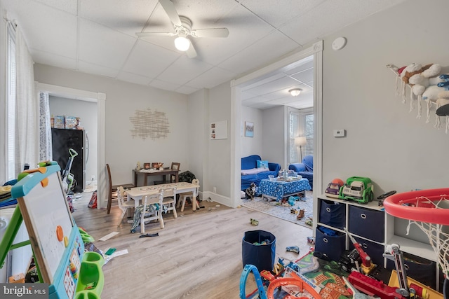 playroom with hardwood / wood-style flooring, a paneled ceiling, and ceiling fan