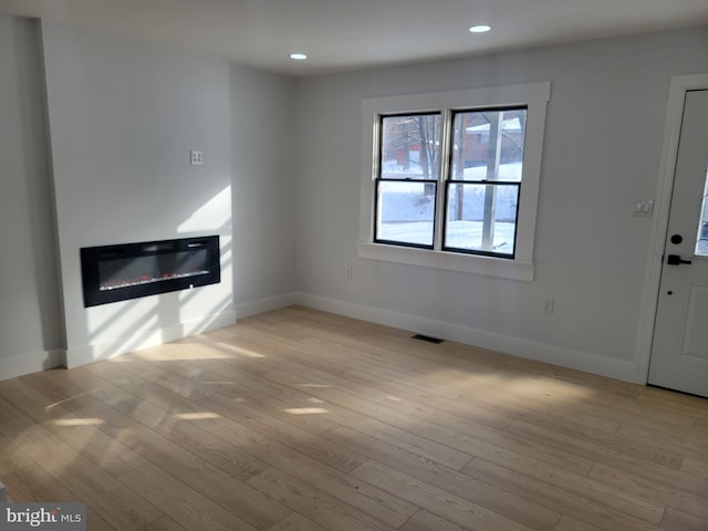 unfurnished living room with light wood-type flooring