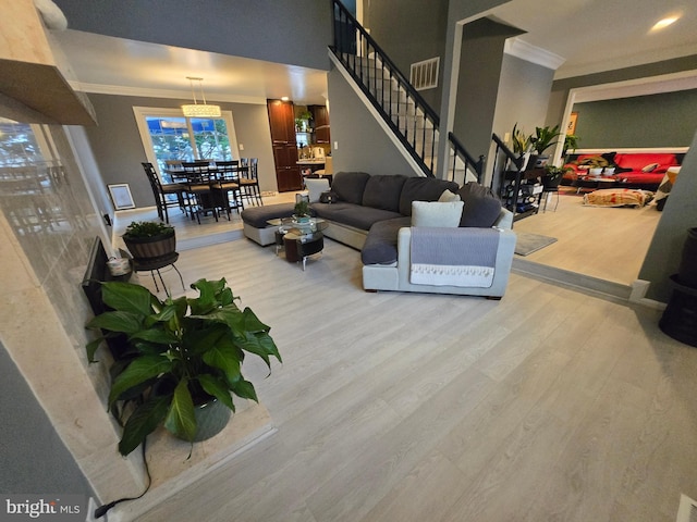 living room with light hardwood / wood-style flooring and ornamental molding