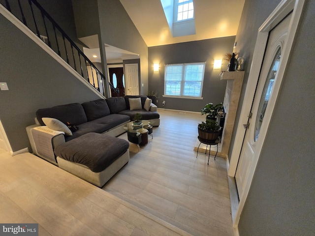 living room featuring light hardwood / wood-style floors and high vaulted ceiling