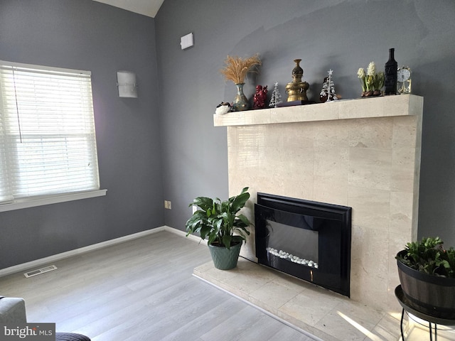 room details featuring wood-type flooring and a tile fireplace