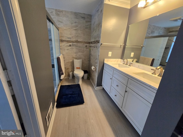 bathroom featuring vanity, hardwood / wood-style flooring, a shower with door, and toilet