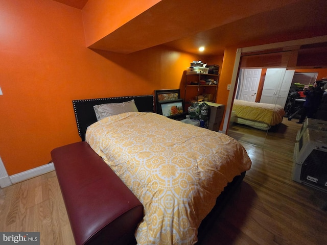 bedroom with dark wood-type flooring and a closet