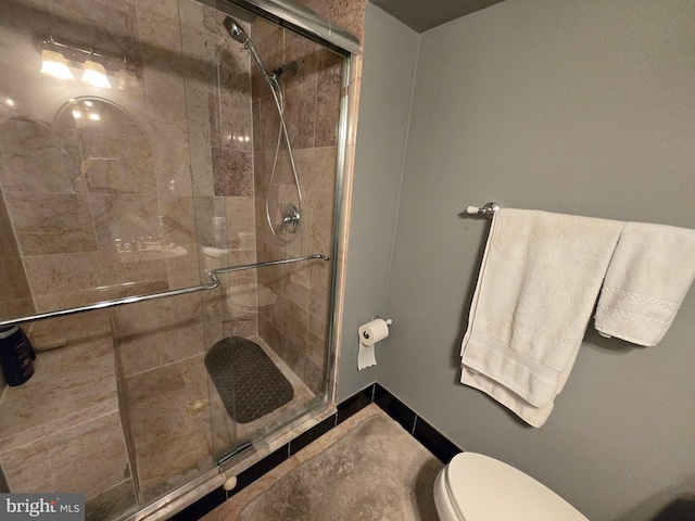 bathroom featuring an enclosed shower and toilet