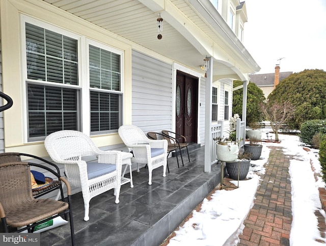 snow covered patio featuring a porch