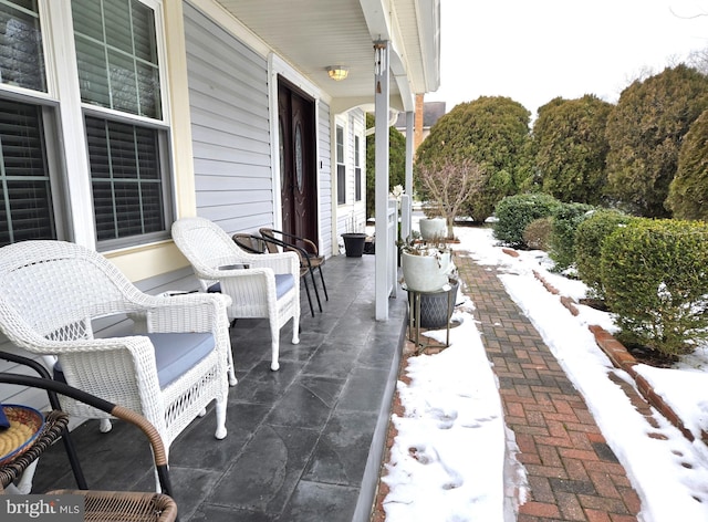 snow covered patio featuring a porch