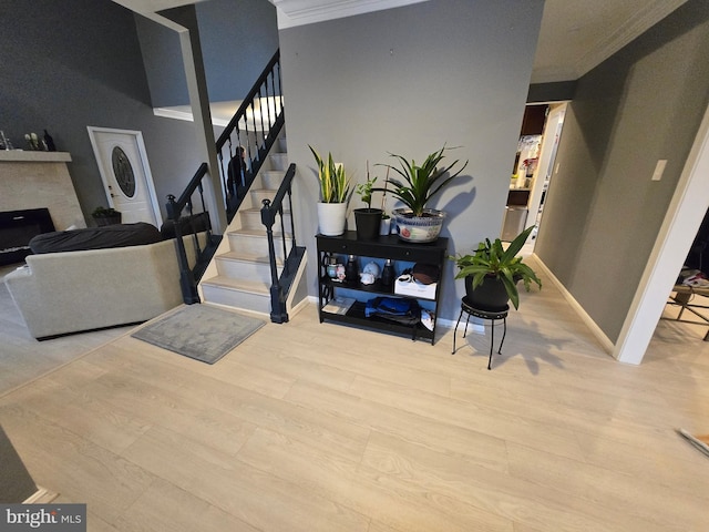 stairs with wood-type flooring and ornamental molding