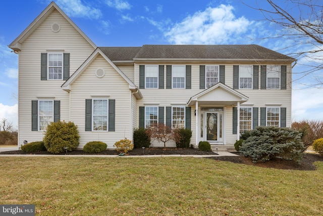 colonial home featuring a front yard