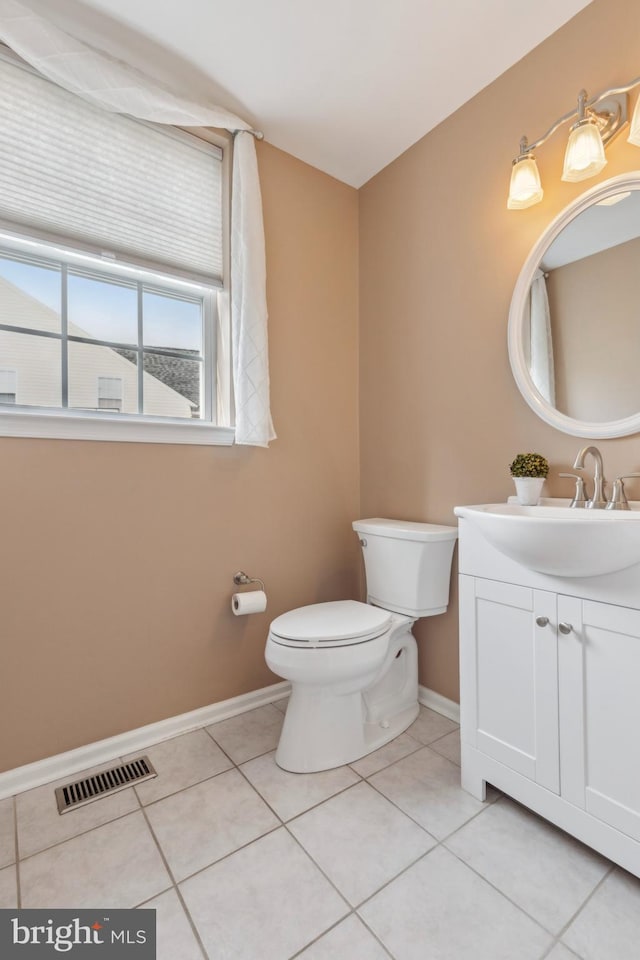 half bath featuring visible vents, vanity, toilet, and tile patterned floors