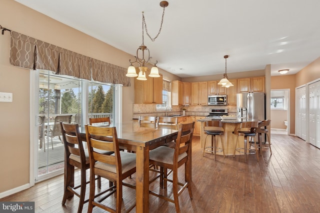 dining space featuring wood finished floors and baseboards