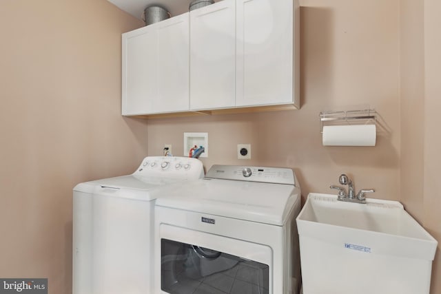 laundry area with washing machine and dryer, cabinet space, and a sink