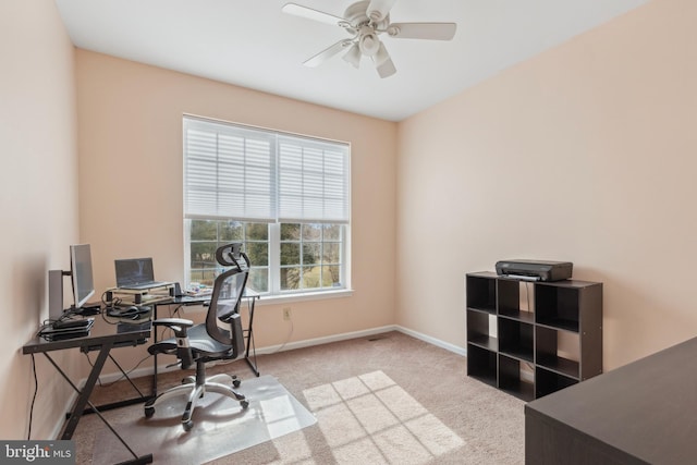 office featuring baseboards, ceiling fan, and light colored carpet