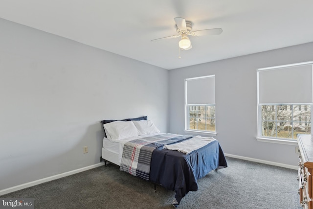 bedroom featuring multiple windows, dark carpet, and baseboards