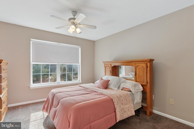 bedroom with dark colored carpet, ceiling fan, and baseboards