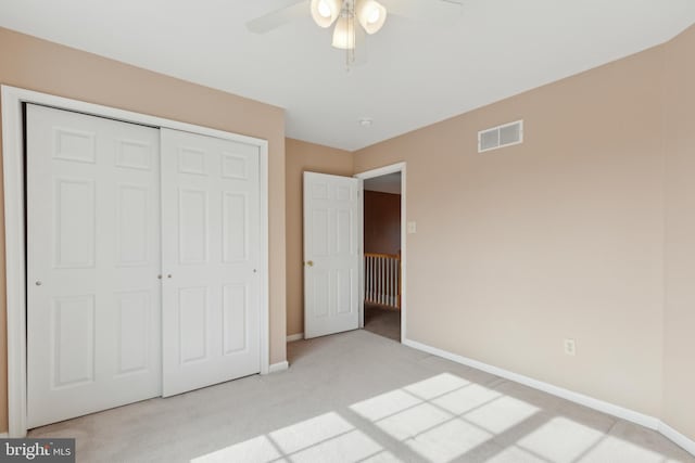 unfurnished bedroom featuring light carpet, baseboards, visible vents, and a closet