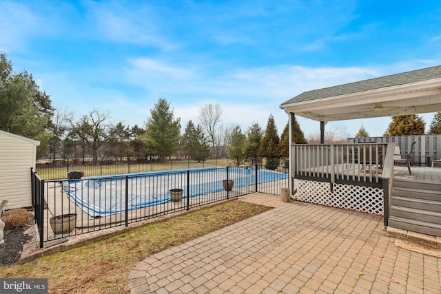 pool featuring a patio, a deck, and fence