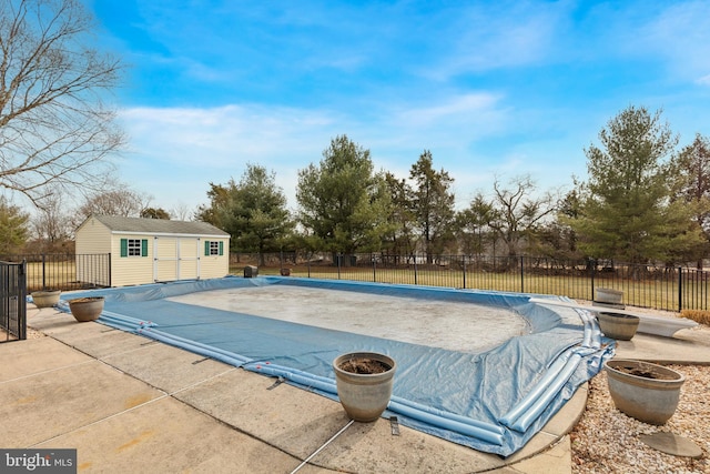 view of pool with a patio, fence, a fenced in pool, and an outdoor structure