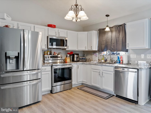 kitchen featuring sink, decorative light fixtures, stainless steel appliances, light stone countertops, and white cabinets