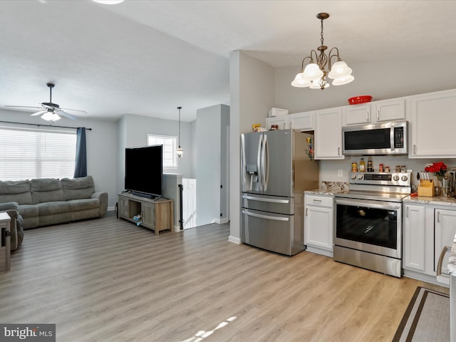 kitchen featuring appliances with stainless steel finishes, decorative light fixtures, and white cabinets