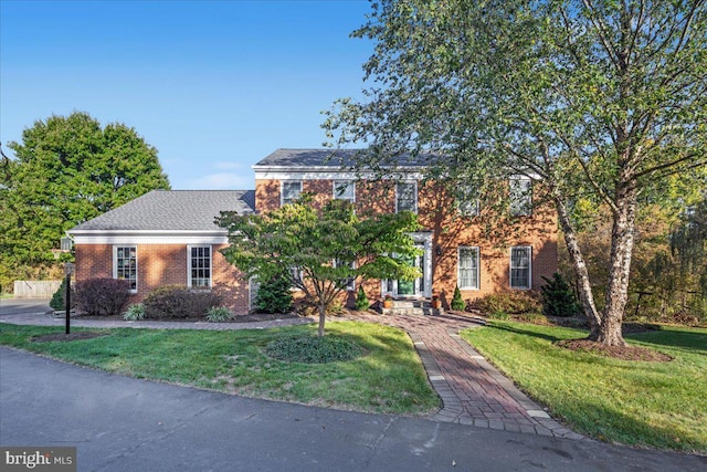 view of front of home featuring a front lawn and brick siding