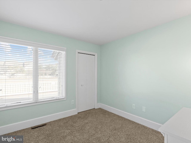 unfurnished bedroom with a closet and carpet