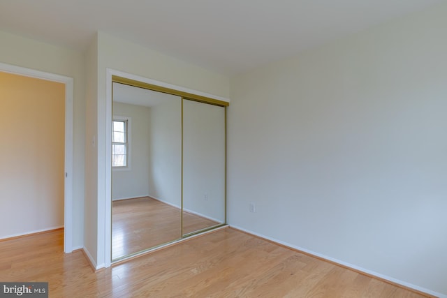 unfurnished bedroom featuring light hardwood / wood-style floors and a closet