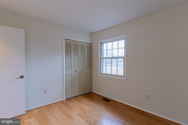 unfurnished bedroom with light hardwood / wood-style flooring and a closet