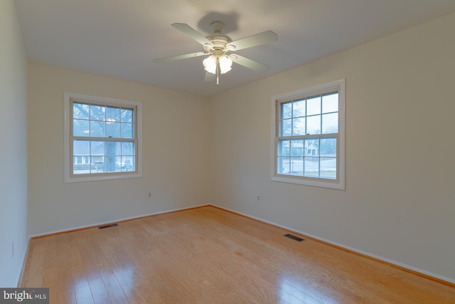 empty room with ceiling fan and light hardwood / wood-style floors