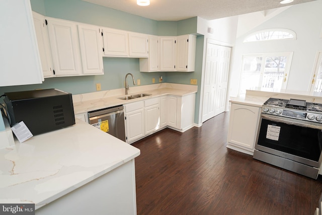 kitchen featuring sink, dark wood-type flooring, white cabinetry, stainless steel appliances, and light stone countertops