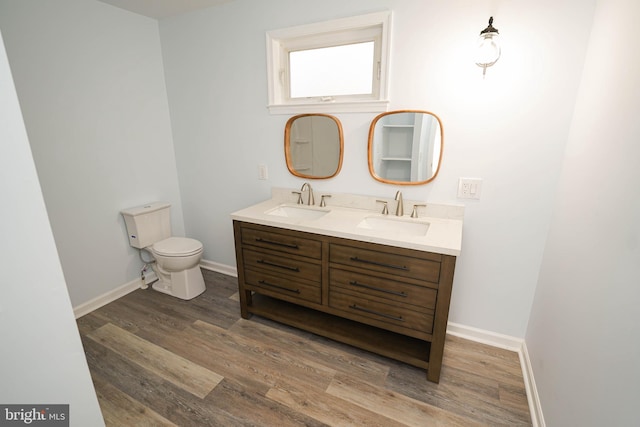 bathroom with vanity, toilet, and hardwood / wood-style floors