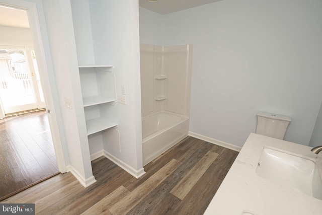 full bathroom with sink, wood-type flooring,  shower combination, and toilet