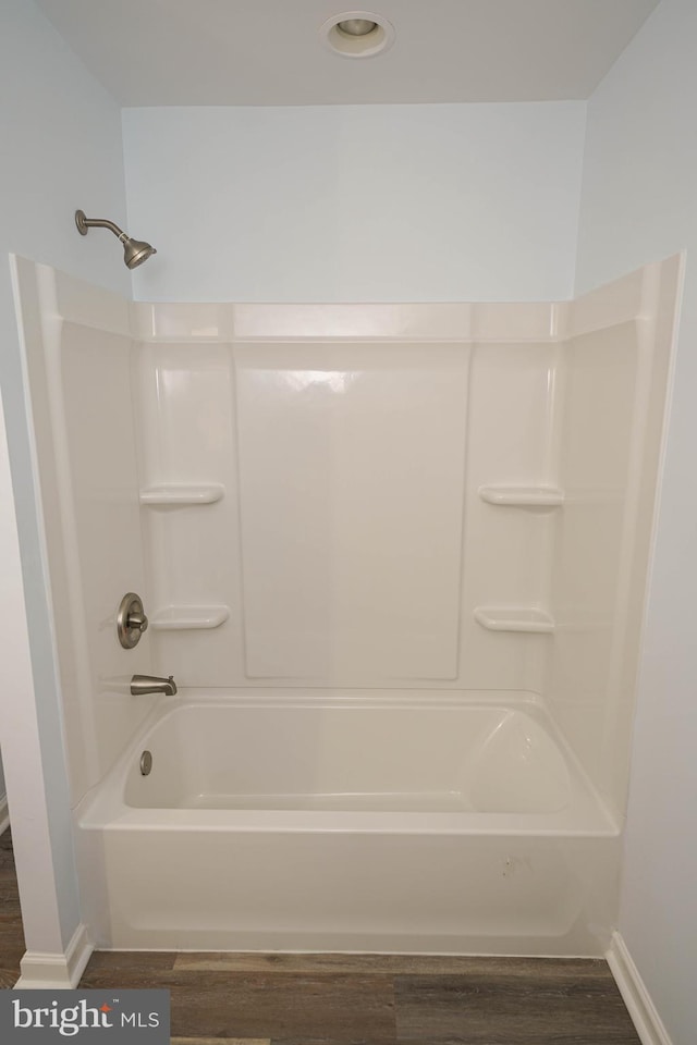 bathroom with bathtub / shower combination and hardwood / wood-style floors