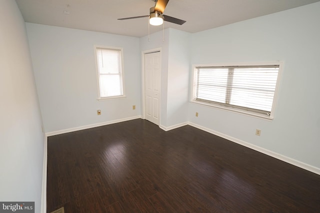 empty room featuring ceiling fan and dark hardwood / wood-style flooring