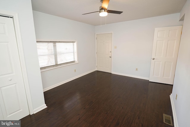 spare room featuring dark wood-type flooring and ceiling fan