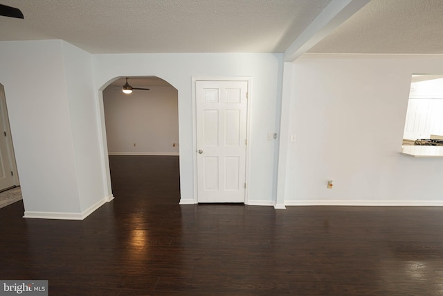 spare room featuring ceiling fan, dark wood-type flooring, and a textured ceiling