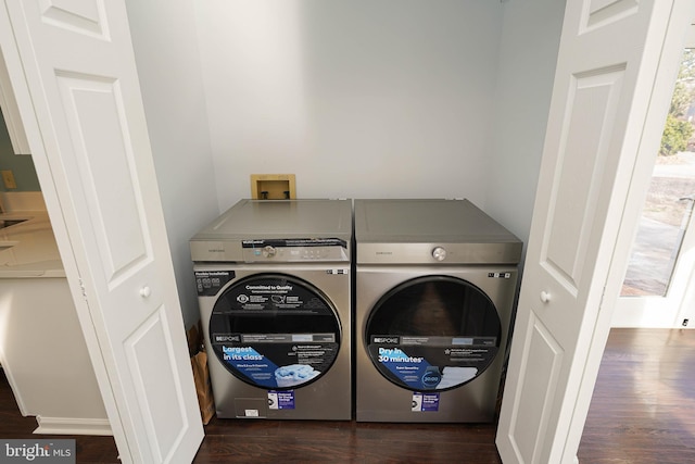 washroom featuring washing machine and clothes dryer and dark hardwood / wood-style flooring