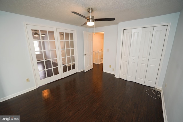 unfurnished bedroom with dark wood-type flooring, ceiling fan, a textured ceiling, french doors, and a closet