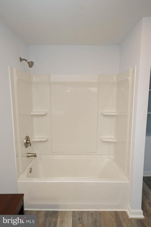 bathroom featuring hardwood / wood-style floors and shower / washtub combination