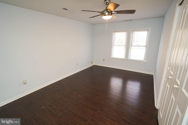 spare room featuring ceiling fan and dark hardwood / wood-style flooring