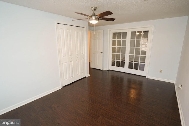 empty room with ceiling fan, a textured ceiling, and dark hardwood / wood-style flooring