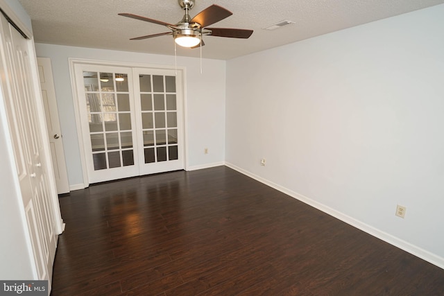 spare room featuring ceiling fan, dark hardwood / wood-style floors, a textured ceiling, and french doors