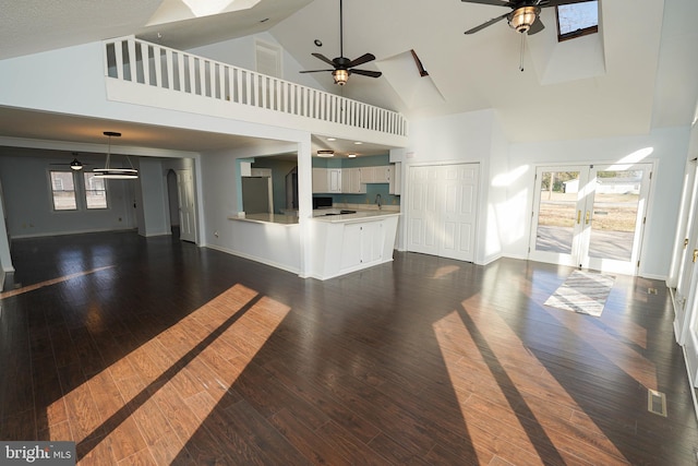 unfurnished living room featuring dark wood-type flooring, ceiling fan, and sink