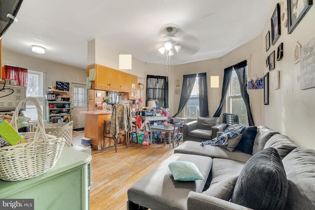 living room featuring light hardwood / wood-style flooring and ceiling fan