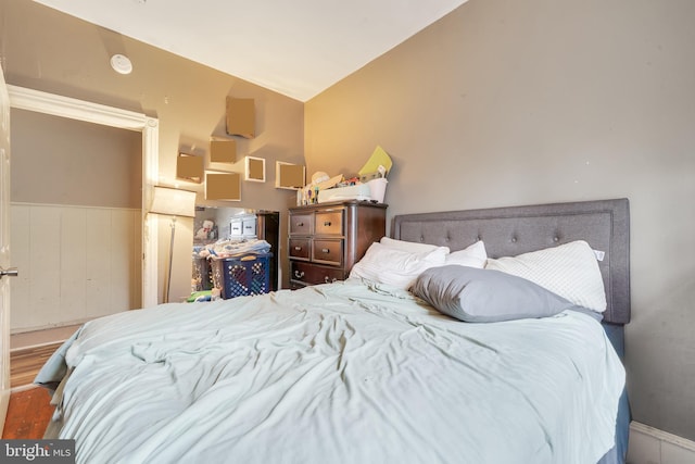 bedroom with lofted ceiling and wood-type flooring