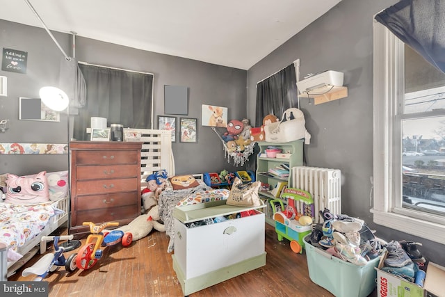 bedroom with radiator and dark hardwood / wood-style floors