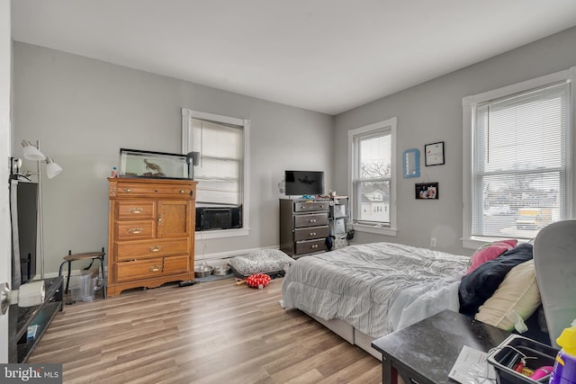 bedroom featuring cooling unit and light hardwood / wood-style floors