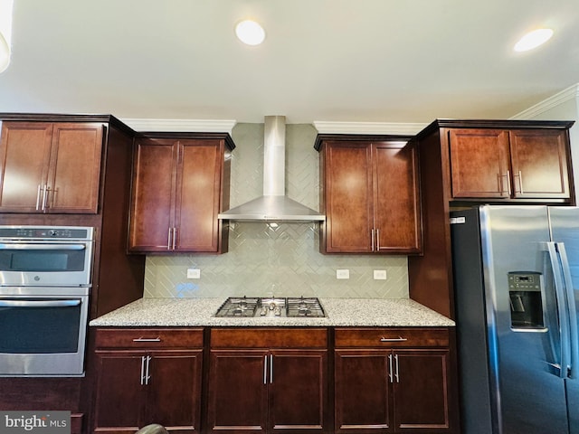 kitchen with appliances with stainless steel finishes, backsplash, crown molding, light stone countertops, and wall chimney exhaust hood