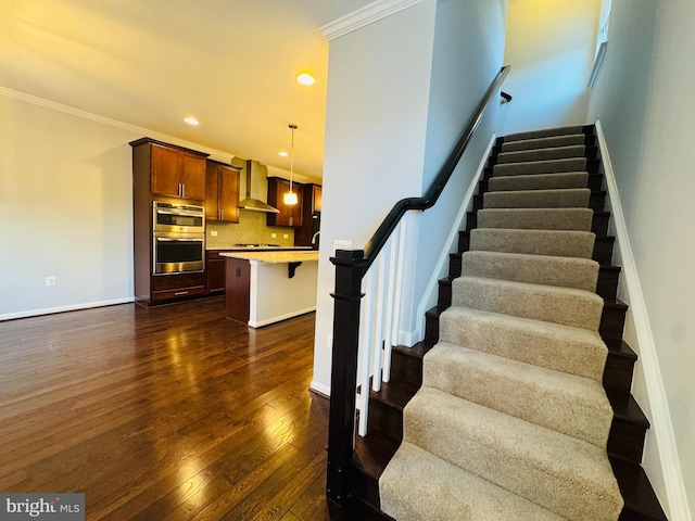 stairs featuring ornamental molding and hardwood / wood-style floors