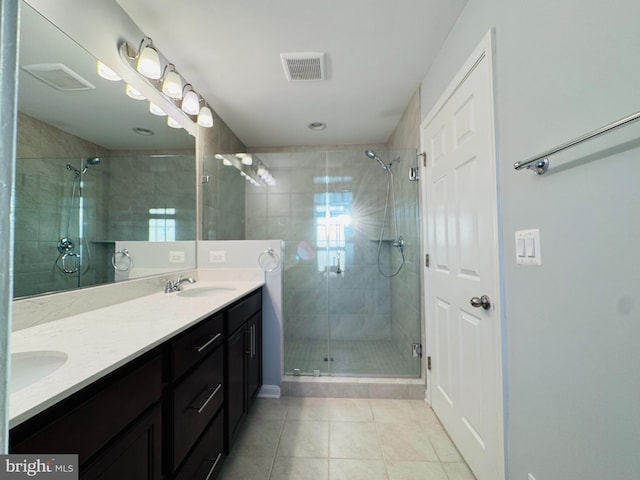 bathroom with tile patterned flooring, vanity, and walk in shower