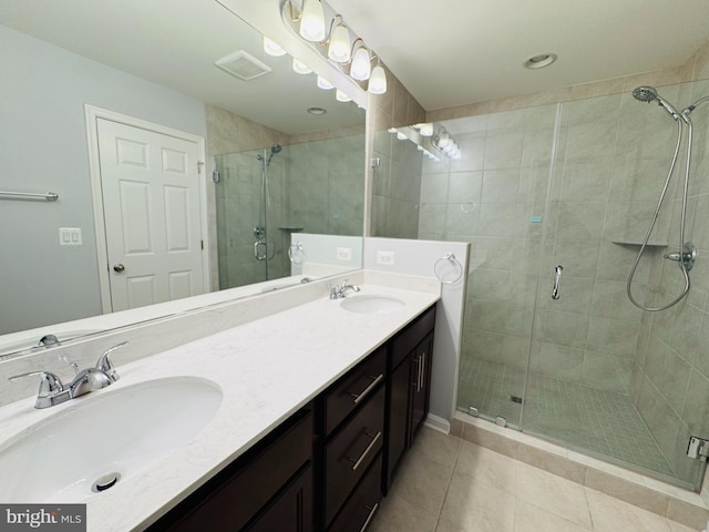 bathroom featuring tile patterned floors, an enclosed shower, and vanity